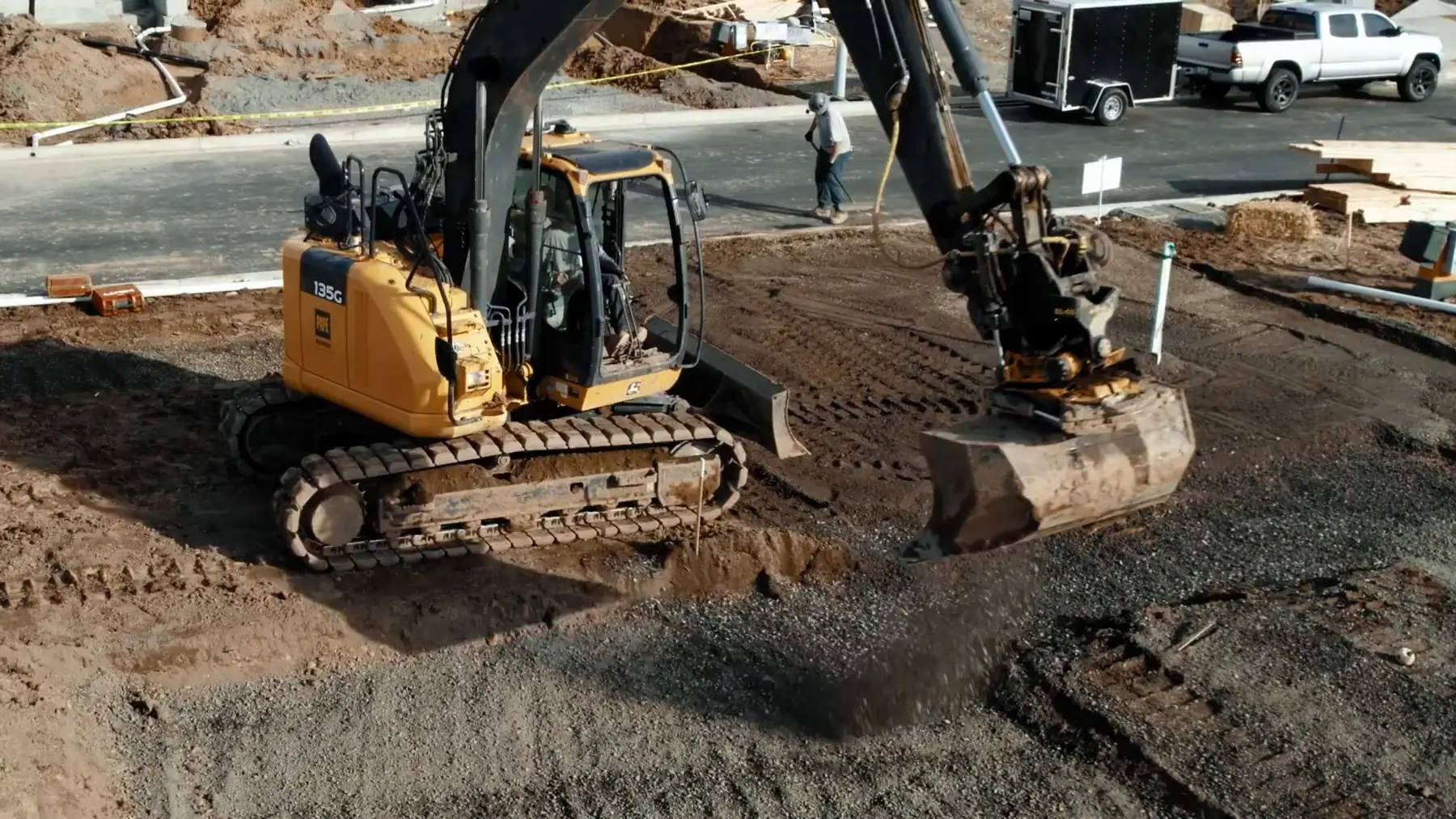 LPG excavator working a building pad on a production lot