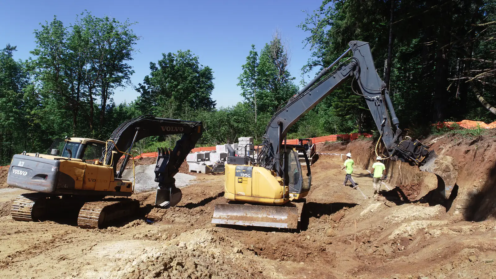 Two excavators and an LPG crew cutting a commercial site