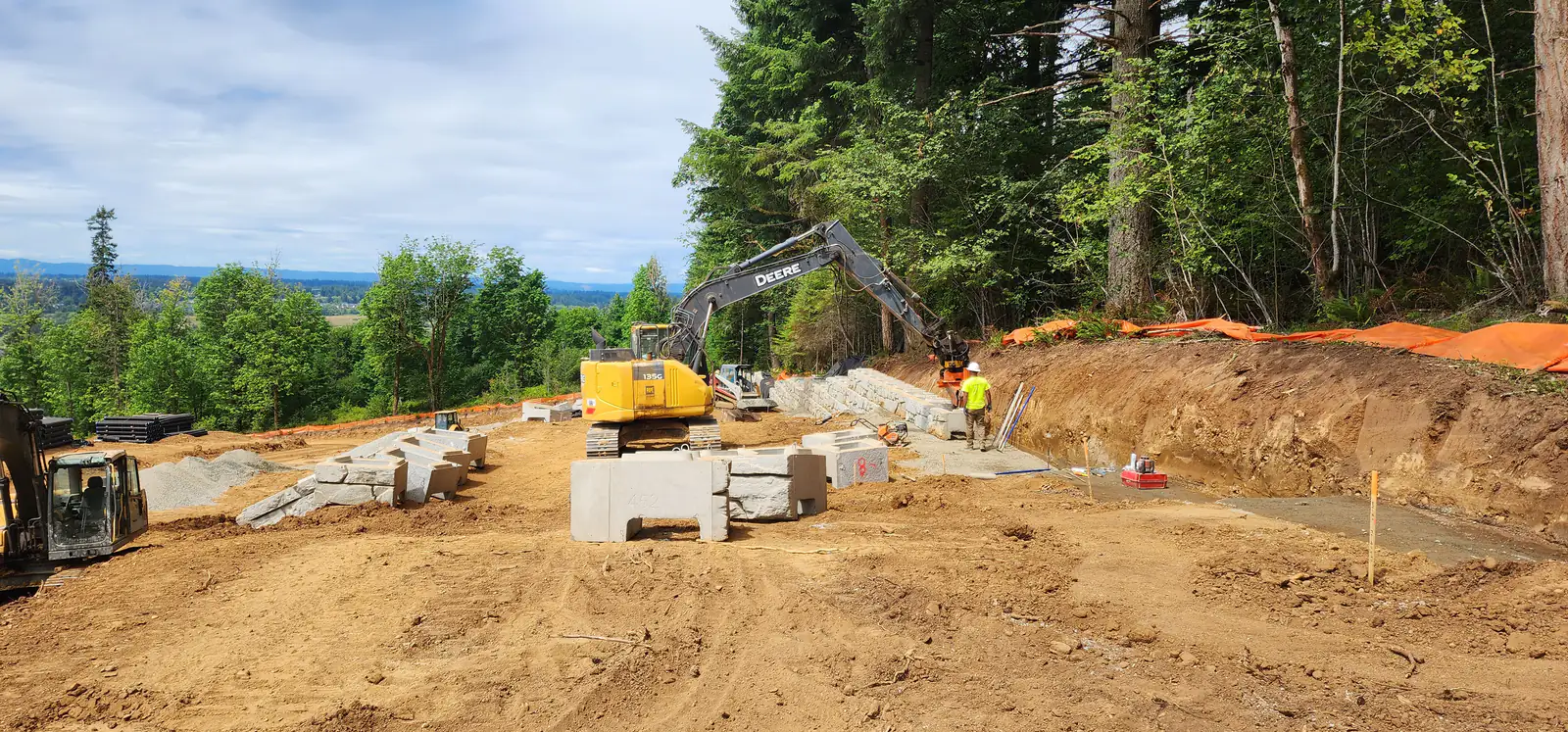 Retaining wall units staged and set along a cut slope